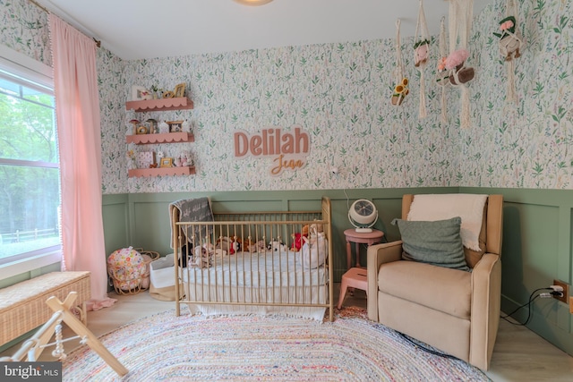 bedroom featuring a crib and hardwood / wood-style flooring