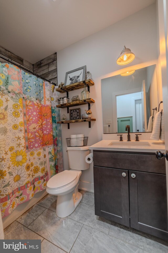 bathroom with vanity, curtained shower, and toilet