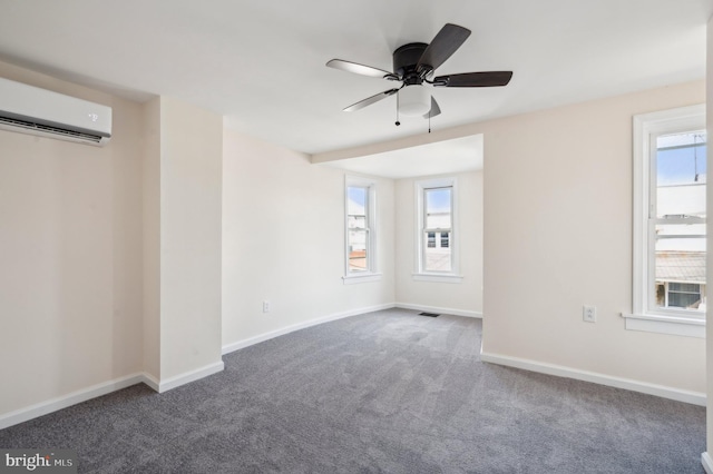 unfurnished room with carpet floors, a wall unit AC, and ceiling fan