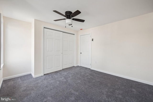 unfurnished bedroom featuring dark colored carpet, ceiling fan, and a closet