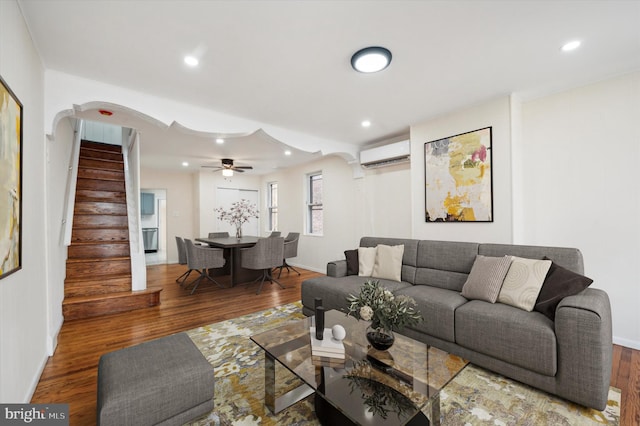 living room with wood-type flooring and an AC wall unit