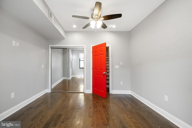 unfurnished bedroom featuring dark wood-type flooring, ceiling fan, and a closet