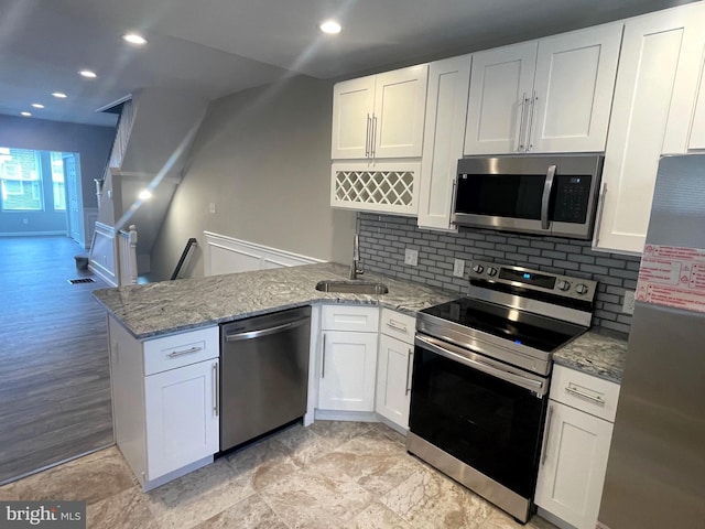 kitchen featuring light hardwood / wood-style floors, appliances with stainless steel finishes, white cabinetry, and sink