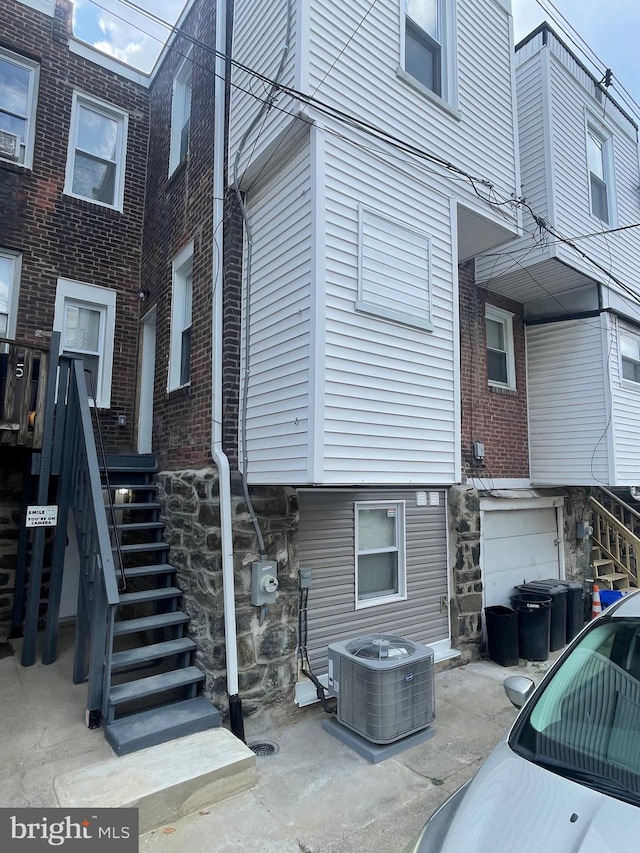 view of side of property with a patio and central air condition unit