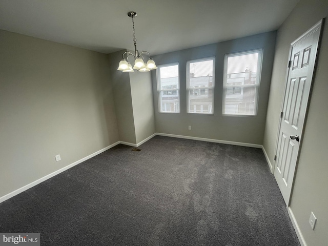 carpeted empty room featuring a notable chandelier