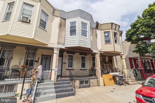 townhome / multi-family property featuring covered porch