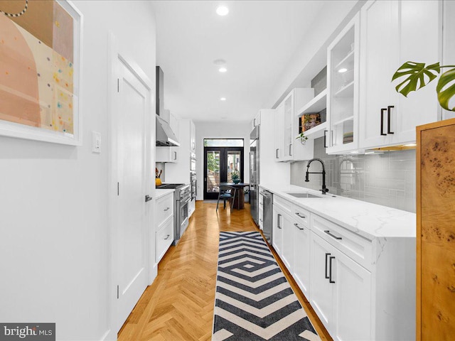 kitchen featuring light parquet floors, sink, premium appliances, and white cabinets