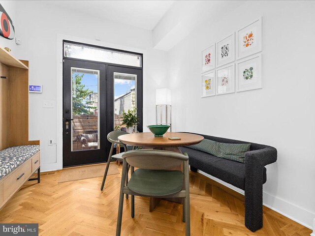 dining area featuring light parquet floors and french doors