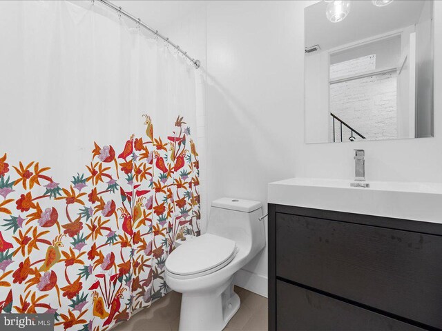 bathroom featuring vanity, tile patterned flooring, and toilet