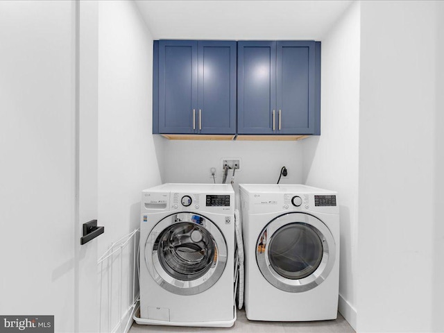 clothes washing area featuring independent washer and dryer and cabinets