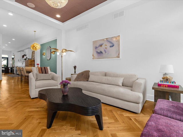 living room featuring light parquet flooring and a tray ceiling