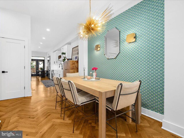 dining room featuring light parquet floors, sink, and an inviting chandelier