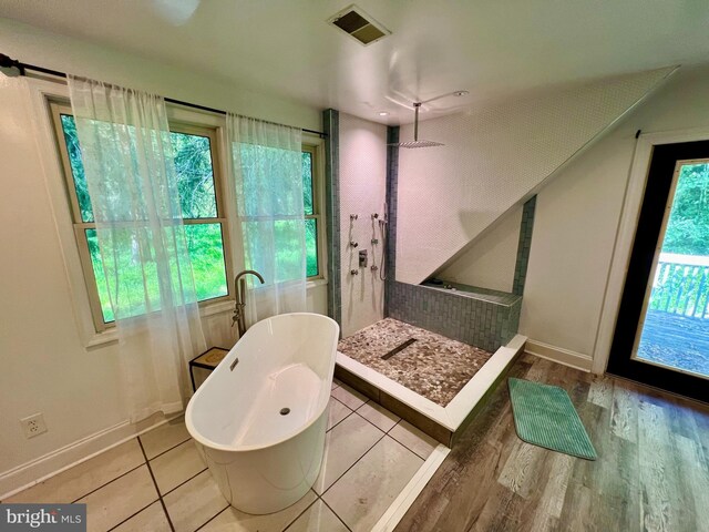 full bathroom with wood finished floors, baseboards, visible vents, a freestanding tub, and walk in shower