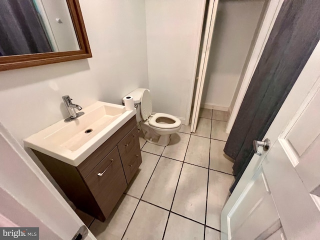 half bathroom with tile patterned flooring, toilet, and vanity