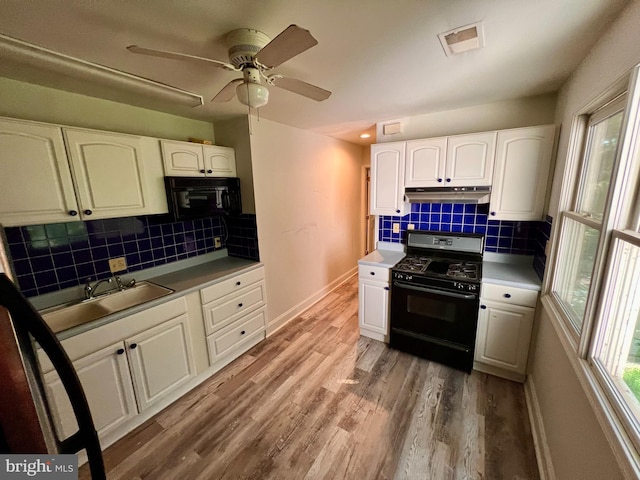 kitchen with black appliances, hardwood / wood-style floors, ceiling fan, and white cabinets