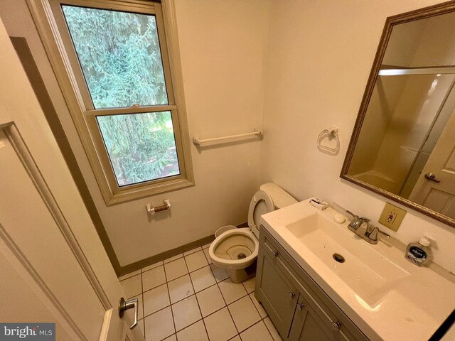 bathroom with baseboards, toilet, vanity, and tile patterned flooring