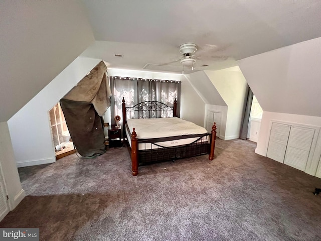 unfurnished bedroom featuring ceiling fan, lofted ceiling, and dark colored carpet