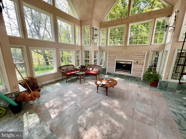 sunroom featuring a glass covered fireplace