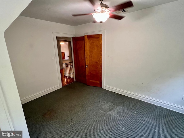 unfurnished bedroom featuring dark colored carpet and ceiling fan