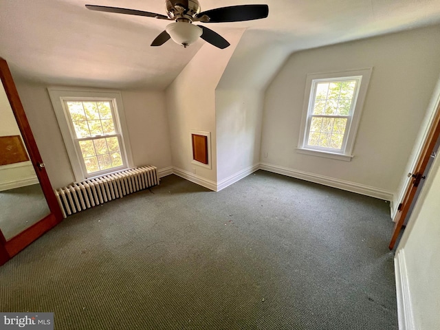 bonus room featuring plenty of natural light, radiator, carpet, and vaulted ceiling