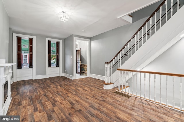 foyer entrance featuring wood-type flooring and a fireplace