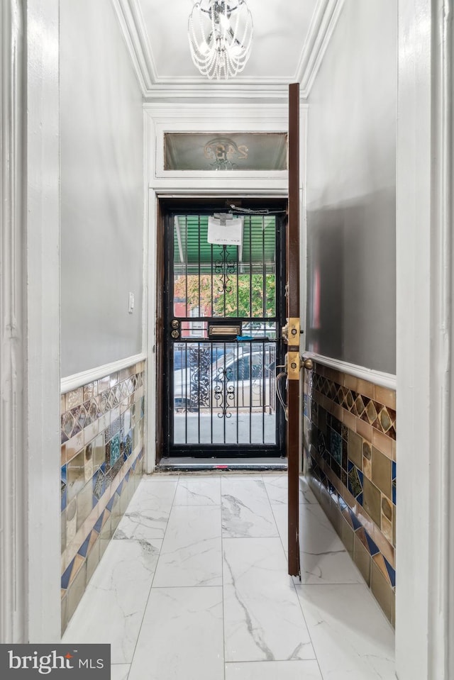 foyer entrance featuring crown molding and a chandelier