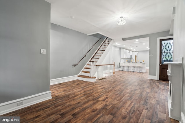 unfurnished living room featuring hardwood / wood-style floors and a notable chandelier