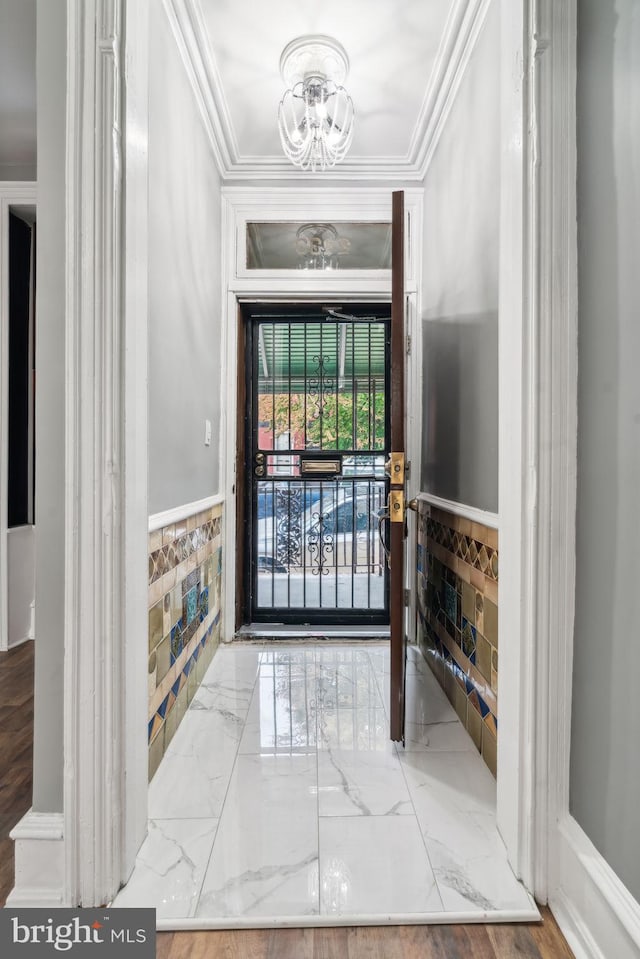 foyer entrance featuring a notable chandelier and crown molding