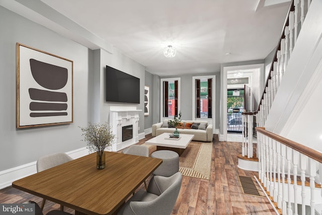 living room with wood-type flooring and a high end fireplace