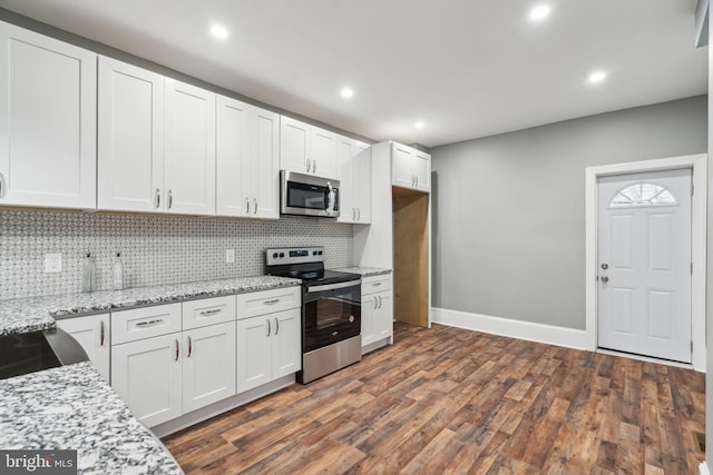 kitchen featuring dark wood-type flooring, backsplash, stainless steel appliances, light stone counters, and white cabinets