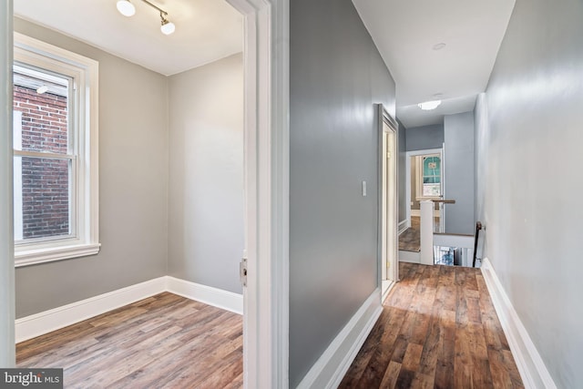 hallway with hardwood / wood-style flooring