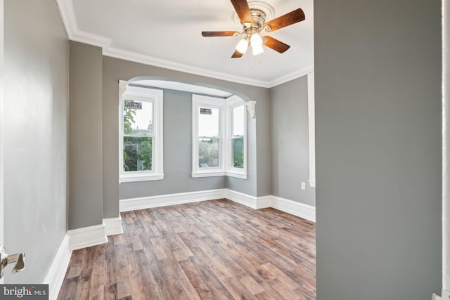 empty room with crown molding, hardwood / wood-style flooring, and ceiling fan