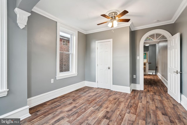 unfurnished room featuring crown molding, dark wood-type flooring, and ceiling fan