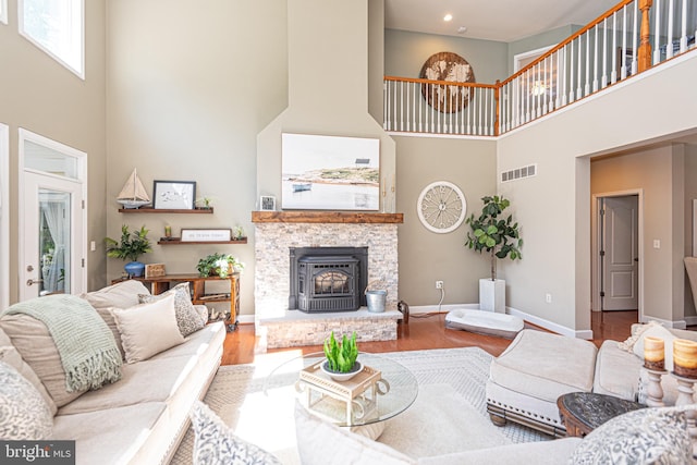 living area with recessed lighting, wood finished floors, visible vents, and baseboards