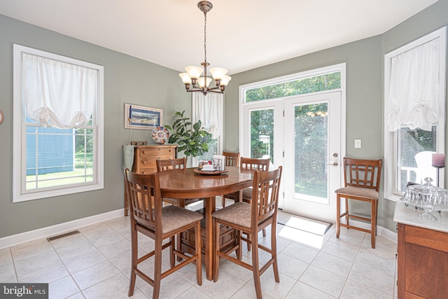 dining room featuring light tile patterned floors, plenty of natural light, and baseboards