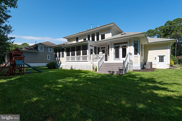 view of front of house with central air condition unit, a sunroom, a front lawn, and a playground