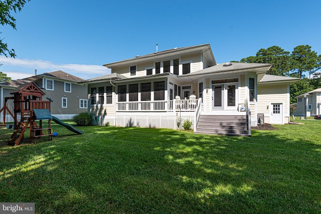 rear view of house featuring a yard, a playground, and a sunroom