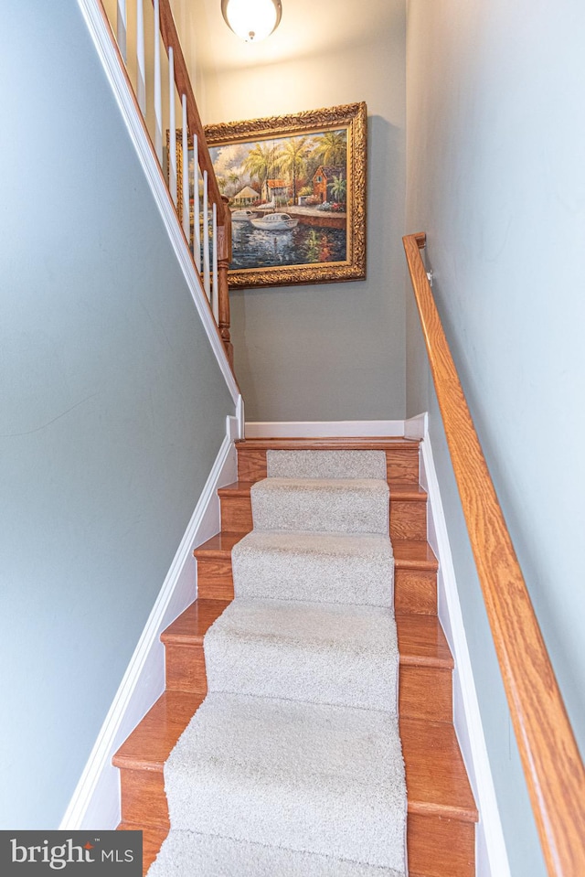 stairway featuring baseboards and wood finished floors