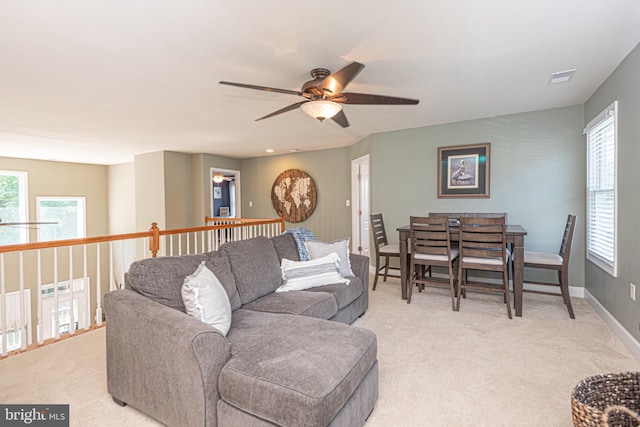 living area featuring light carpet, baseboards, and visible vents