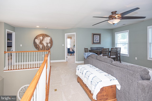 living area with light carpet, visible vents, and baseboards