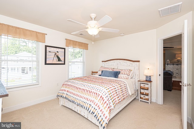 bedroom featuring light carpet, ceiling fan, visible vents, and baseboards