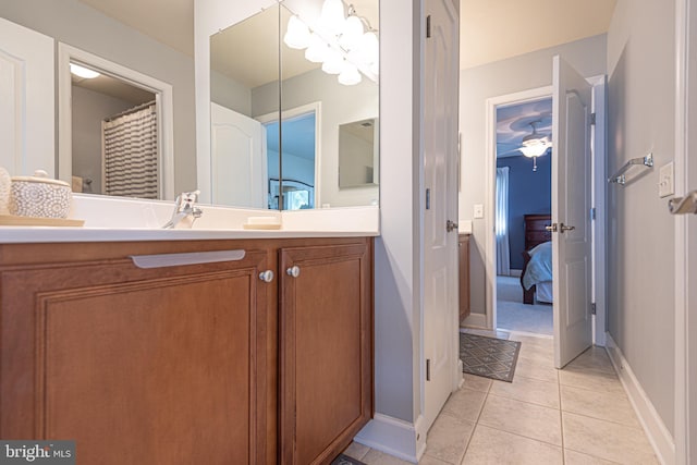 ensuite bathroom featuring baseboards, ensuite bath, vanity, and tile patterned floors