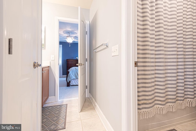 hallway featuring light tile patterned floors and baseboards