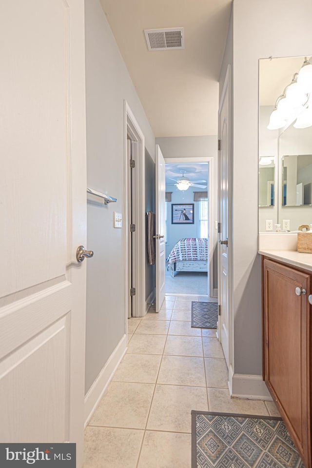 ensuite bathroom featuring visible vents, baseboards, ensuite bathroom, tile patterned flooring, and vanity