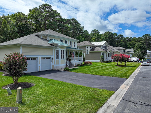 view of front facade featuring a porch, aphalt driveway, an attached garage, roof with shingles, and a front yard