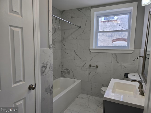 full bathroom with tiled shower / bath, vanity, toilet, and tile walls