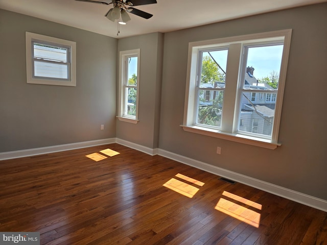 unfurnished room featuring ceiling fan, plenty of natural light, and dark hardwood / wood-style floors