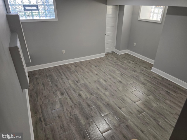 basement with dark wood-type flooring and plenty of natural light