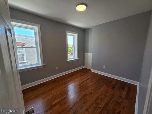 empty room with dark hardwood / wood-style flooring