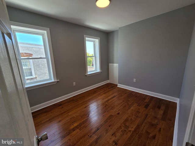 unfurnished room with dark hardwood / wood-style floors